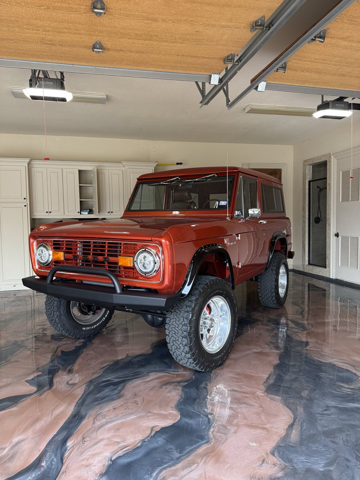 Mocha metallic epoxy garage floor under a red Ford Bronco in McKinney, TX