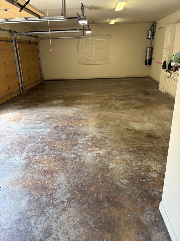Before: stained, peeling concrete garage floor before epoxy coating